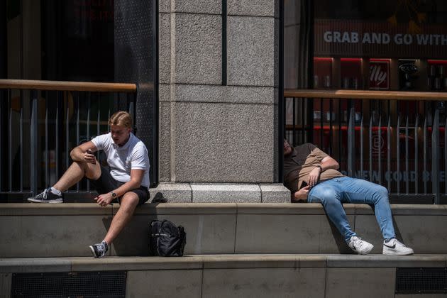 Men relax in the sun on Monday in London. (Photo: Carl Court via Getty Images)