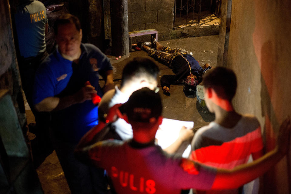 <p>Officials stanad over the body of an alleged drug dealer killed by an unidentified assailant in Manila, Philippines, March 29, 2017. (Noel Celis/AFP/Getty Images) </p>