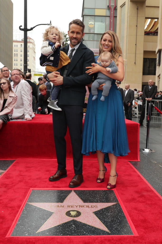 Ryan Reynolds in a suit, Blake Lively in a blue dress, with their two children, at Reynolds' Hollywood Walk of Fame star ceremony