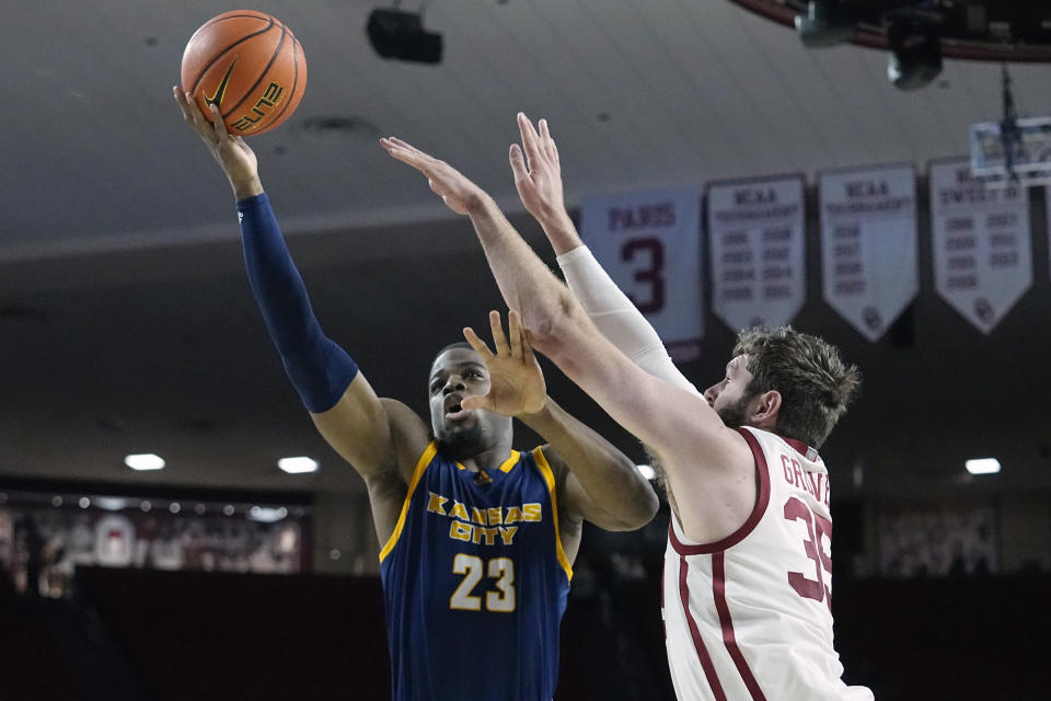 Kansas City forward Allen David Mukeba Jr. (23) shoots in front of Oklahoma forward Tanner Groves in the first half of an NCAA college basketball game, Tuesday, Dec. 6, 2022, in Norman, Okla. (AP Photo/Sue Ogrocki)