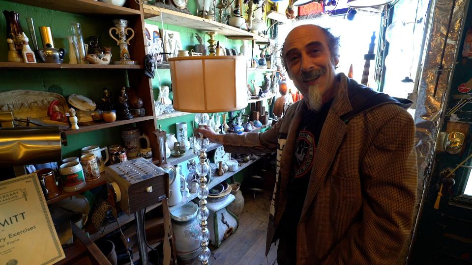 Junktiques owner Phinneus Sonin shows off a lamp he found on the side of the road in New York City.