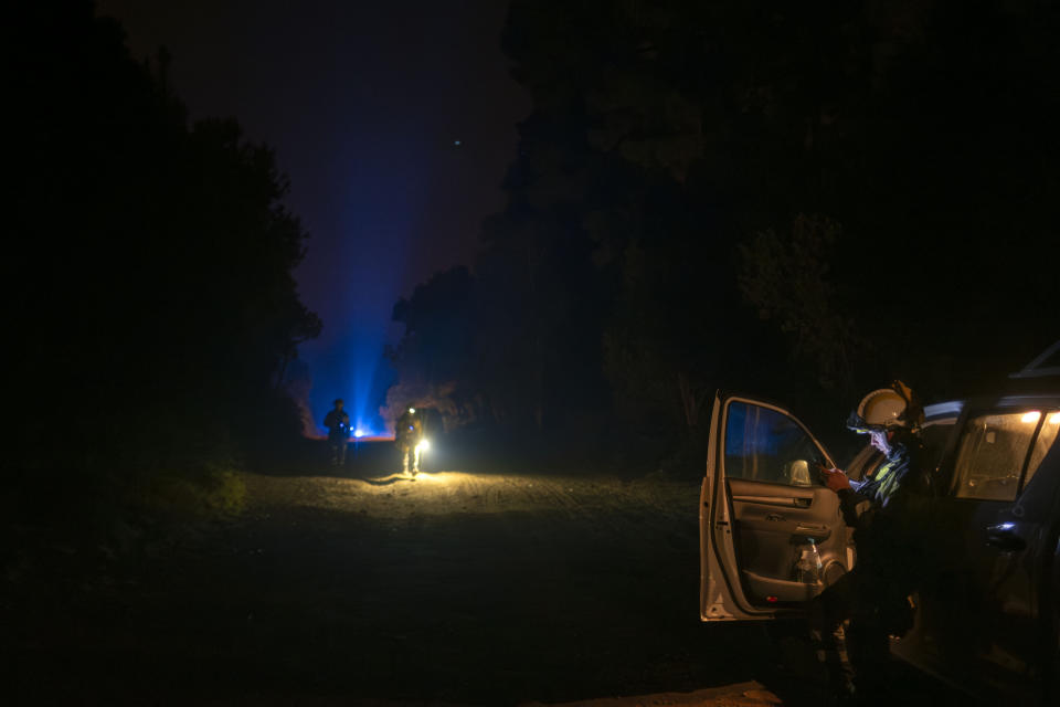 Emergency crews and firefighters work near the fire advancing through the forest toward the town of El Rosario in Tenerife, Canary Islands, Spain on Friday, Aug. 18, 2023. Officials say a wildfire is burning out of control through the Spanish Canary Island of Tenerife, affecting nearly 8,000 people who have been evacuated or ordered to stay indoors. (AP Photo/Arturo Rodriguez)