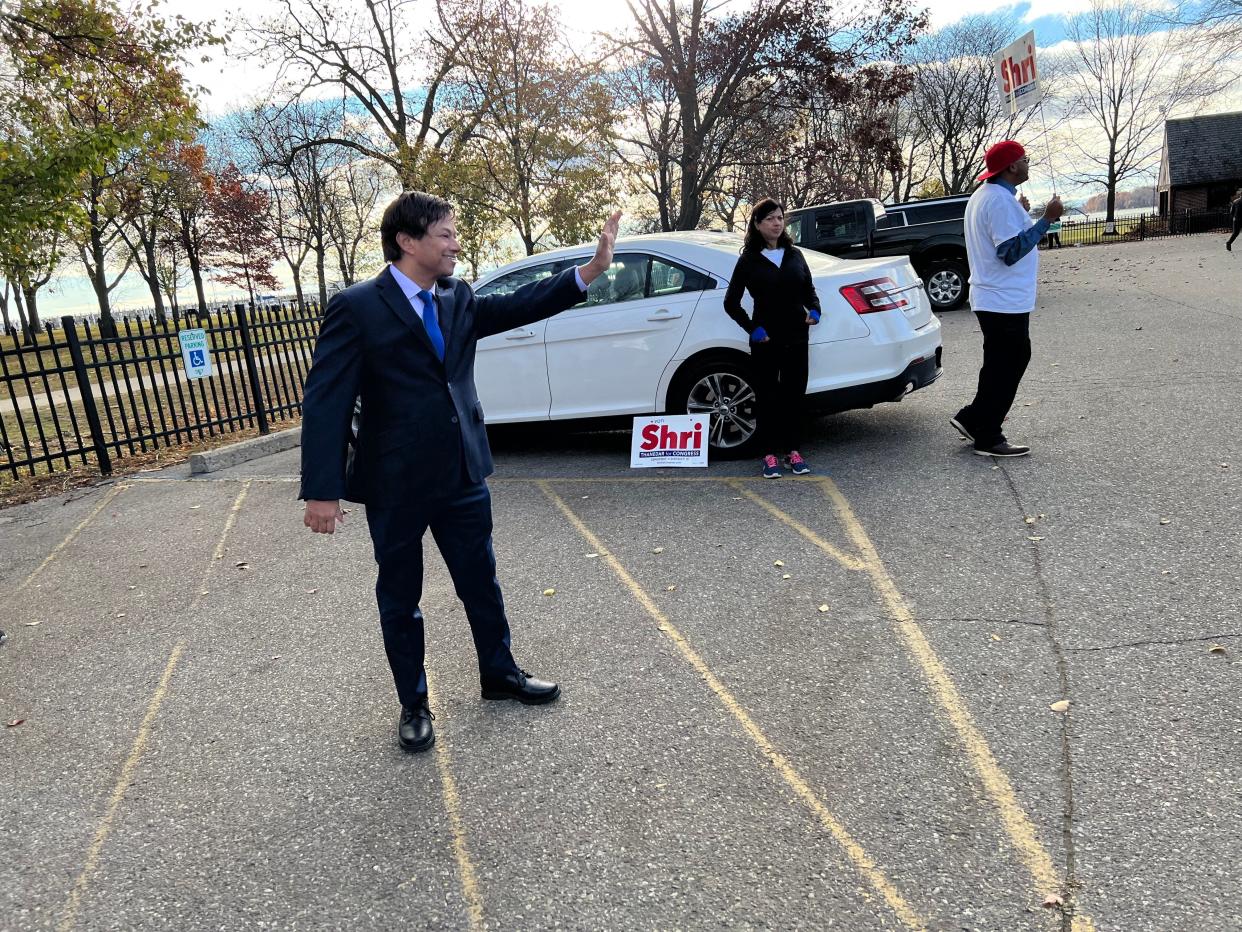 Democratic candidate for the 13th Congressional District Shri Thanedar waves to voters headed to vote in Grosse Pointe Park at the Lavins Activity Center on Nov. 8, 2022. His wife, Shashi, and supporter Wendell Smiley, of Detroit, were with the candidate showing their support.