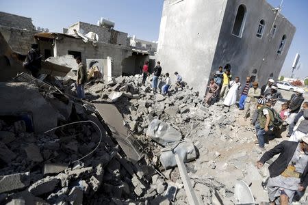 People stand on the rubble of houses destroyed by an air strike near Sanaa Airport March 31, 2015. REUTERS/Khaled Abdullah
