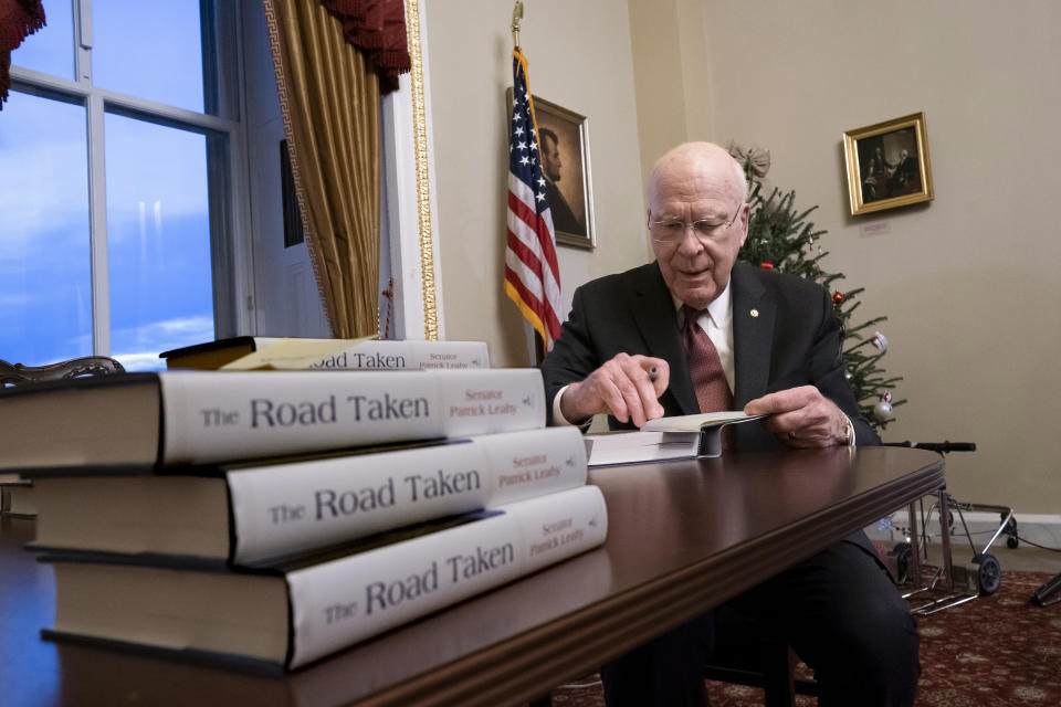 Sen. Patrick Leahy, D-Vt., signs his book, The Road Taken, at his office at the Capitol in Washington, Monday, Dec. 19, 2022. The U.S. Senate's longest-serving Democrat, Leahy is getting ready to step down after almost 48 years representing his state in the U.S. Senate. (AP Photo/J. Scott Applewhite)