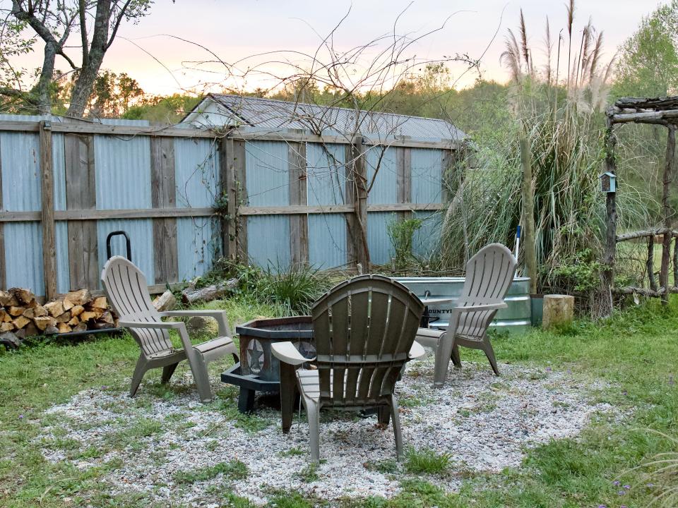 View of three adirondack chairs around a metal fire pit