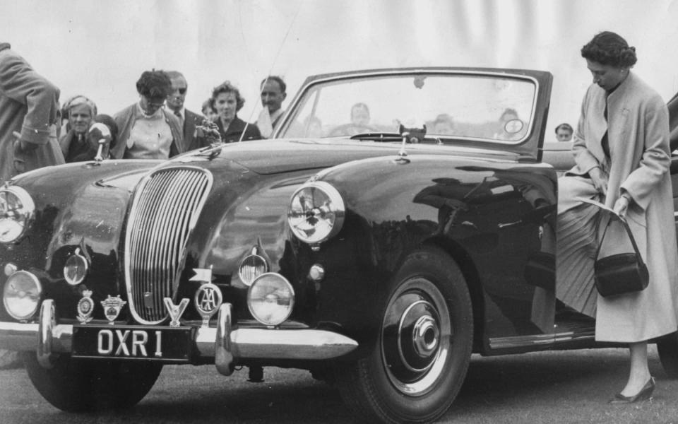 The Queen and Prince Philip get into their Aston Martin Lagonda after a polo match in June 1956 - Getty 