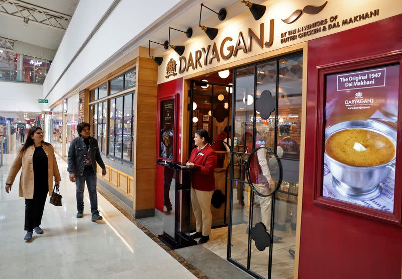 People walk past the Daryaganj restaurant at a mall in Noida