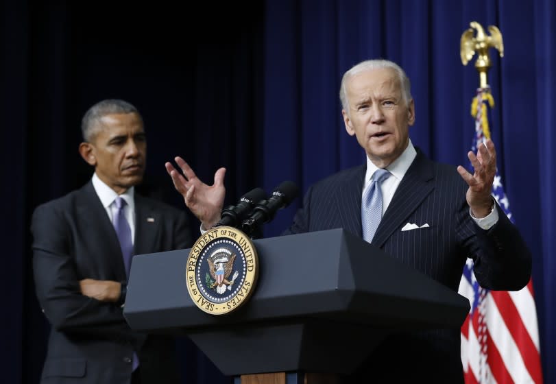 President Barack Obama listens as Vice President Joe Biden speaks in the South Court Auditorium in the Eisenhower Executive Office Building on the White House complex in Washington, Tuesday, Dec. 13, 2016, before the president signed the 21st Century Cures Act. (AP Photo/Carolyn Kaster)