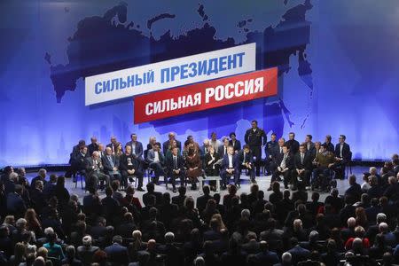 Members of the initiative group to nominate Vladimir Putin as a candidate in the 2018 presidential election attend a meeting in Moscow, Russia December 26, 2017. The inscription on the board reads "Strong President. Strong Russia". REUTERS/Sergei Karpukhin