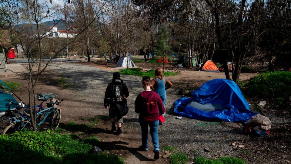 PHOTO: Cassy Leach, right, leads a group of volunteers to check on homeless people living in Baker Park, Mar. 21, 2024, in Grants Pass, Ore. (Jenny Kane/AP)