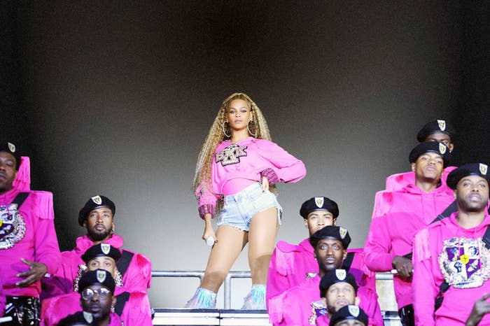 Beyoncé stands at the top of bleachers