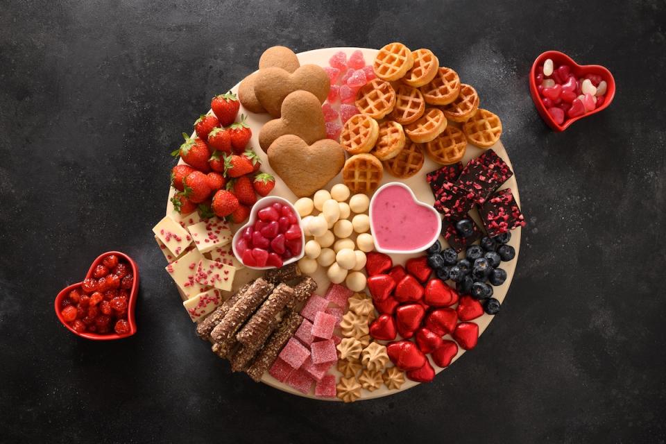 Dessert charcuterie-style board with cookies, strawberries, and various chocolates and candies