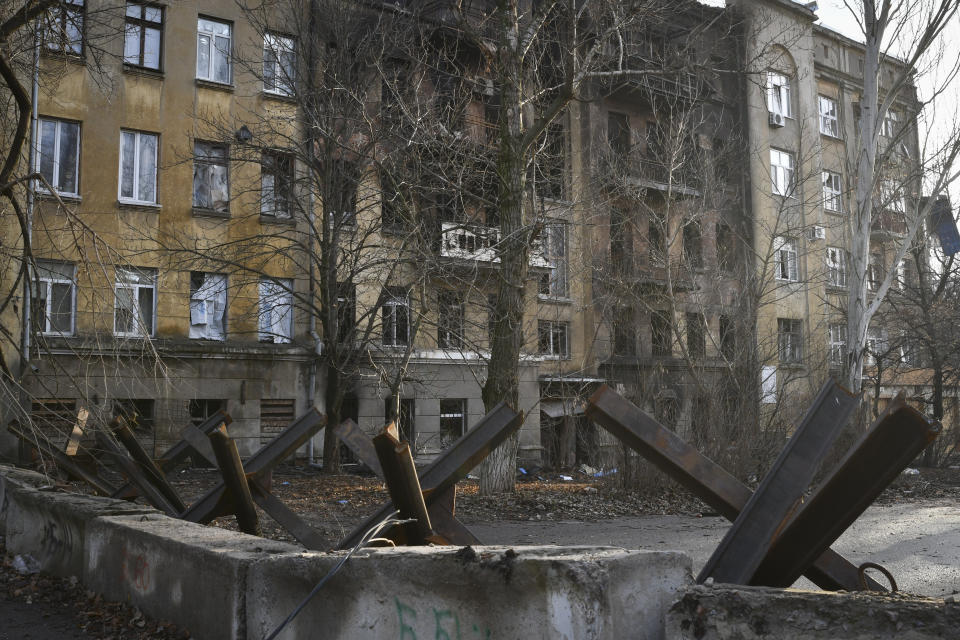 Anti-tank hedgehogs against the background of an apartment house damaged in the Russian shelling in Bakhmut, the site of the heaviest battles with the Russian troops, in the Donetsk region, Ukraine, Sunday, Dec. 11, 2022. (AP Photo/Andriy Andriyenko)