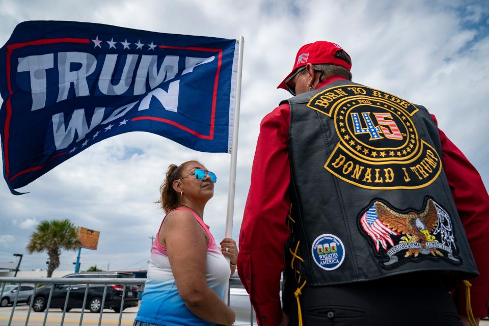 Trump supporters Maria Alexander and Chris Perry wait along the motorcade route for former President Donald Trump to return home to Mar-a Lago following his arraignment in New York on April 4, 2023. 