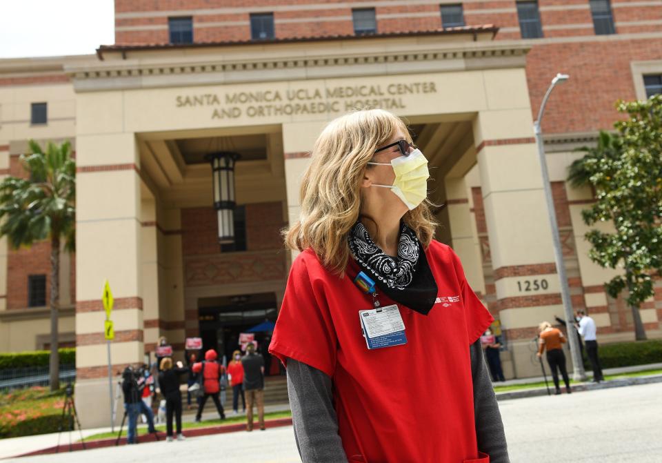 A nurse wearing a protective mask participates in a rally to support the National Nurses United and California Nurses Association's demand for personal protective equipment for healthcare workers across the state at UCLA Medical Center Santa Monica, in April 13, 2020, in Santa Monica, California. (Photo by VALERIE MACON / AFP) (Photo by VALERIE MACON/AFP via Getty Images)