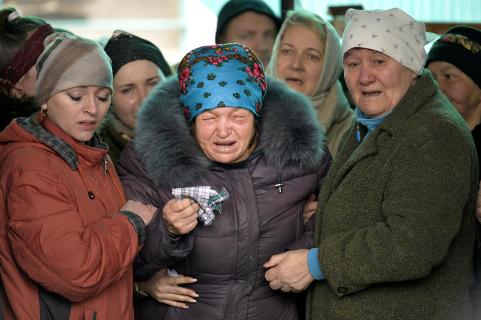 The mother of Russian Army soldier Rustam Zarifulin, who was killed fighting in Ukraine, cries surrounded by relatives during a farewell ceremony in his hometown of Kara-Balta, west of Bishkek, Kyrgyzstan, Sunday, March 27, 2022. (AP Photo/Vladimir Voronin)