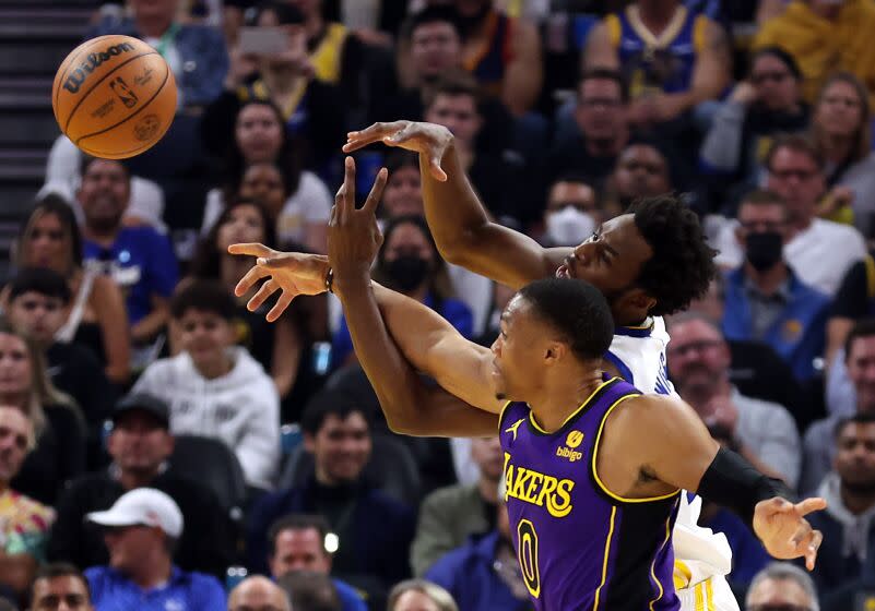 SAN FRANCISCO, CALIFORNIA - OCTOBER 18: Andrew Wiggins #22 of the Golden State Warriors and Russell Westbrook #0 of the Los Angeles Lakers compete for the ball during the 1st half of the game at Chase Center on October 18, 2022 in San Francisco, California. NOTE TO USER: User expressly acknowledges and agrees that, by downloading and or using this photograph, User is consenting to the terms and conditions of the Getty Images License Agreement. (Photo by Ezra Shaw/Getty Images)