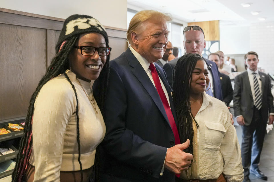 Republican presidential candidate former President Donald Trump, center, takes a photo with Michaelah Montgomery, left, a local conservative activist, as he visits a Chick-fil-A eatery, Wednesday, April 10, 2024, in Atlanta. (AP Photo/Jason Allen)