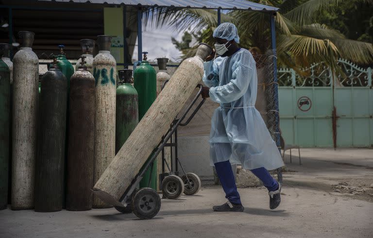 Un empleado de hospital transporta un tubo de oxígeno en Puerto Príncipe