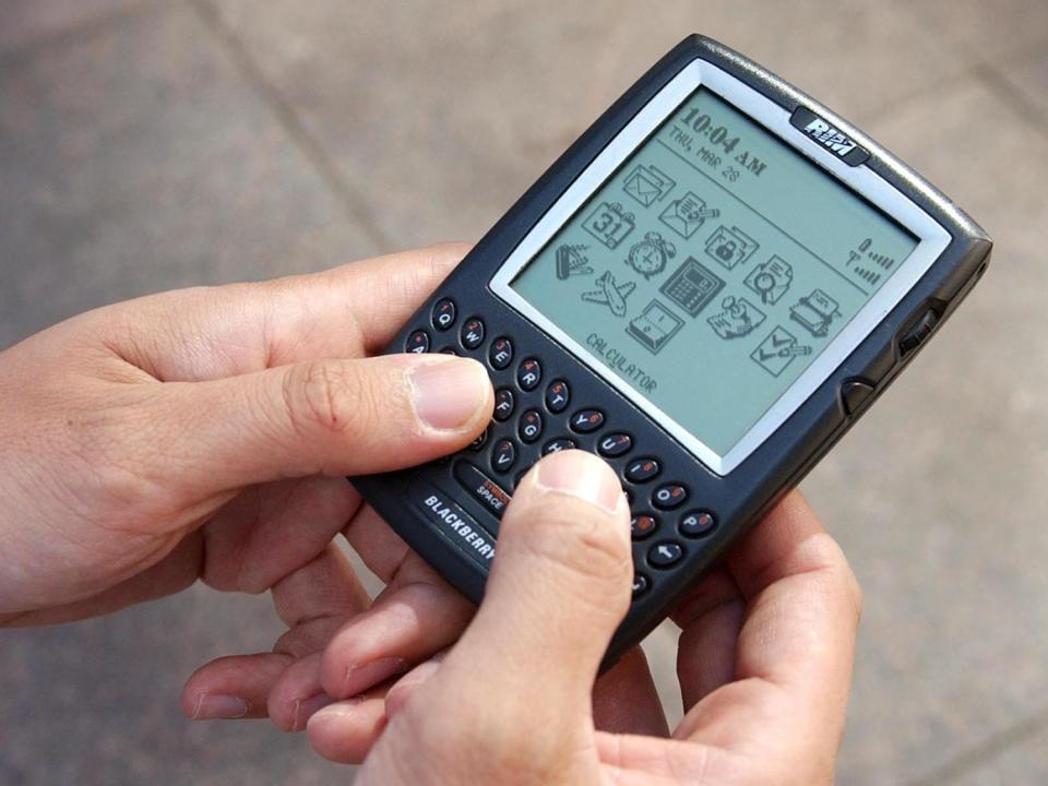 Man uses RIM - Blackberry handheld pda, photo