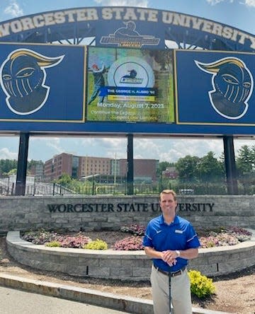 Worcester State University athletic director Michael Mudd stands in front of the WSU message board promoting the George Albro Memorial Golf Tournament on Aug. 7 at Cyprian Keyes GC.