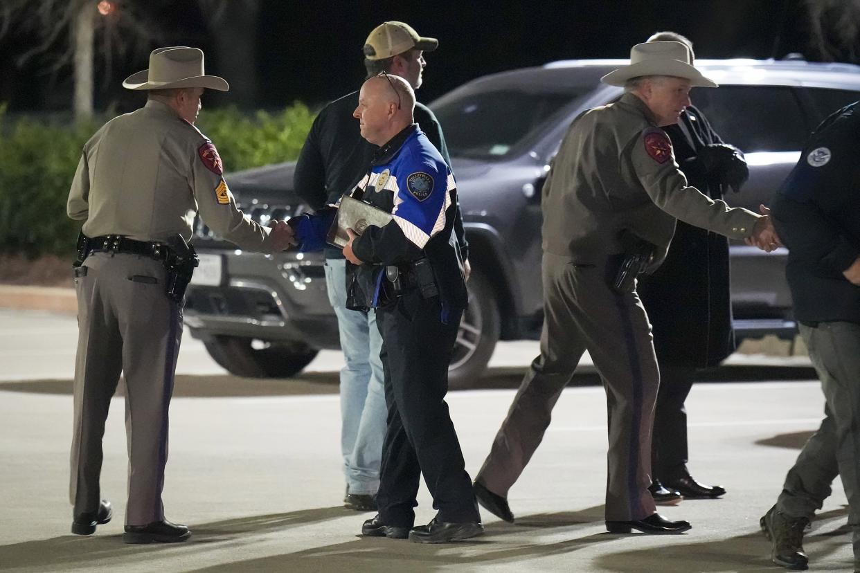 Colleyville police Chief Michael Miller, center in blue jacket, shakes hands with fellow law enforcement officers after addressing reporters after the conclusion of a SWAT operation at Congregation Beth Israel synagogue on Saturday, Jan. 15, 2022, in Colleyville, Texas.