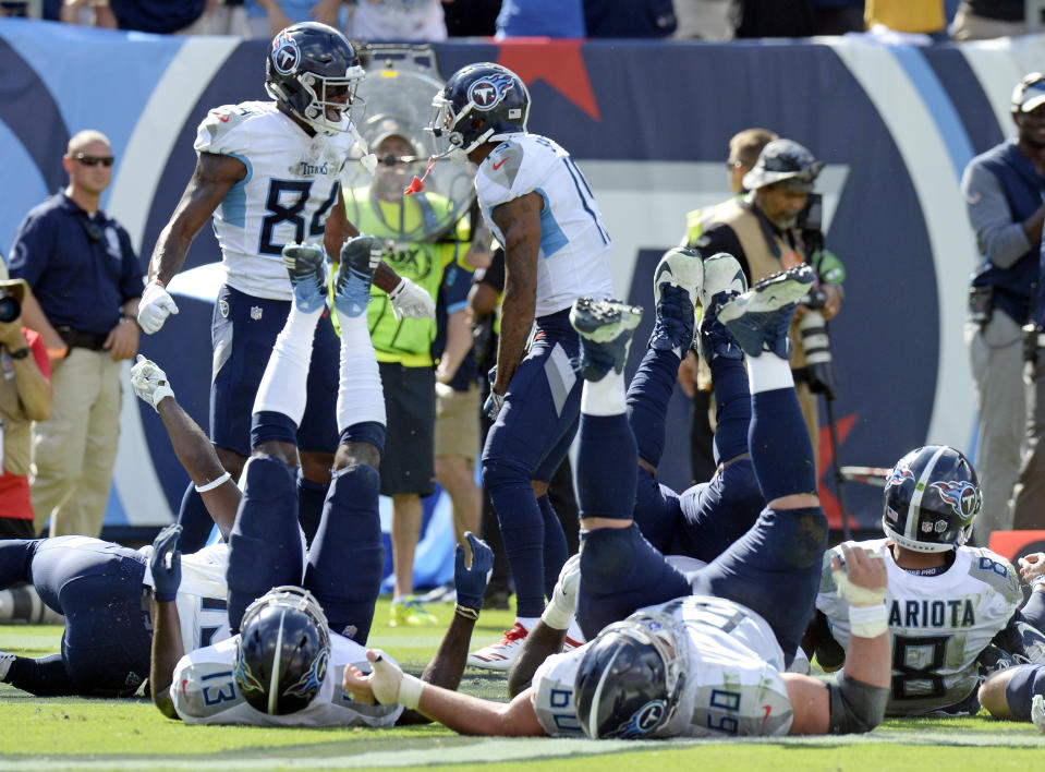 Tennessee Titans players fall over like bowling pins as they celebrate after wide receiver Tajae Sharpe (19) caught a touchdown pass against the Philadelphia Eagles in the second half of an NFL football game Sunday, Sept. 30, 2018, in Nashville, Tenn. With Sharpe is wide receiver Corey Davis (84). (AP Photo/Mark Zaleski)