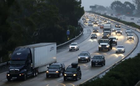 Traffic moves through the rain along interstate 5 in Encinitas, California December 3, 2014. Nearly two-thirds of Americans would support roadway user fees to help fix the country's crumbling transportation infrastructure, according to a survey to be published on April 28, 2016 that was seen by Reuters. REUTERS/Mike Blake/File Photo