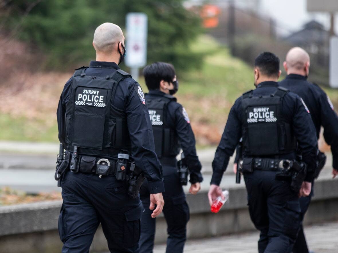 Surrey Police Service officers are pictured in Surrey, British Columbia, on Tuesday, Jan. 25, 2022. The force has announced that one of its members is suspended with pay after Surrey RCMP arrested the officer on Tuesday in relation to a breach of trust investigation. (Ben Nelms/CBC - image credit)