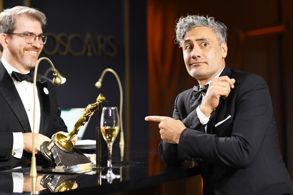 Taika Waititi looks bemused while waiting for his Oscar for Best Adapted Screenplay to be engraved. 