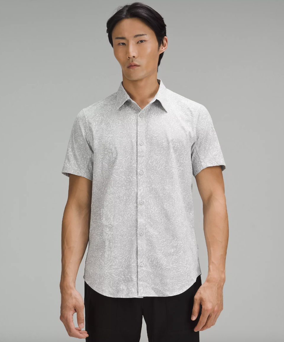 male model wearing black pants and light grey pattern Airing Easy Short Sleeve Button-Up Shirt (photo via lululemon)