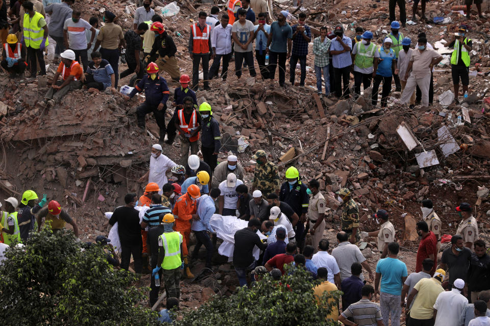 National Disaster Response Force (NDRF) officials carry a dead body which was recovered from the debris after a five storey building collapsed in Mahad in Raigad district in the western state of Maharashtra. REUTERS/Francis Mascarenhas