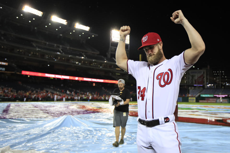 Washington Nationals Bryce Harper (34) bows his head and raise his arms with clenched fists as the Nationals celebrate and bid goodbye to their fans ending their last home game of the season with a 9-3 rain delayed win against the Miami Marlins in Washington, Wednesday, Sept. 26, 2018. (AP Photo/Manuel Balce Ceneta)