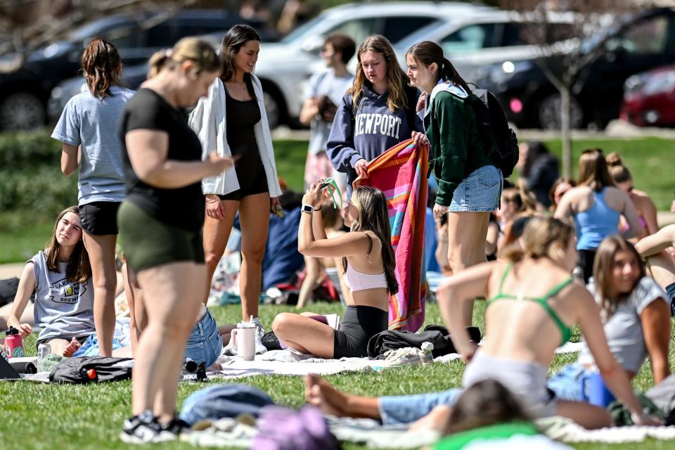 People set up on the lawn next to Michigan State University's Cowles House to watch the solar eclipse on Monday, April 8, 2024, on the MSU campus in East Lansing.