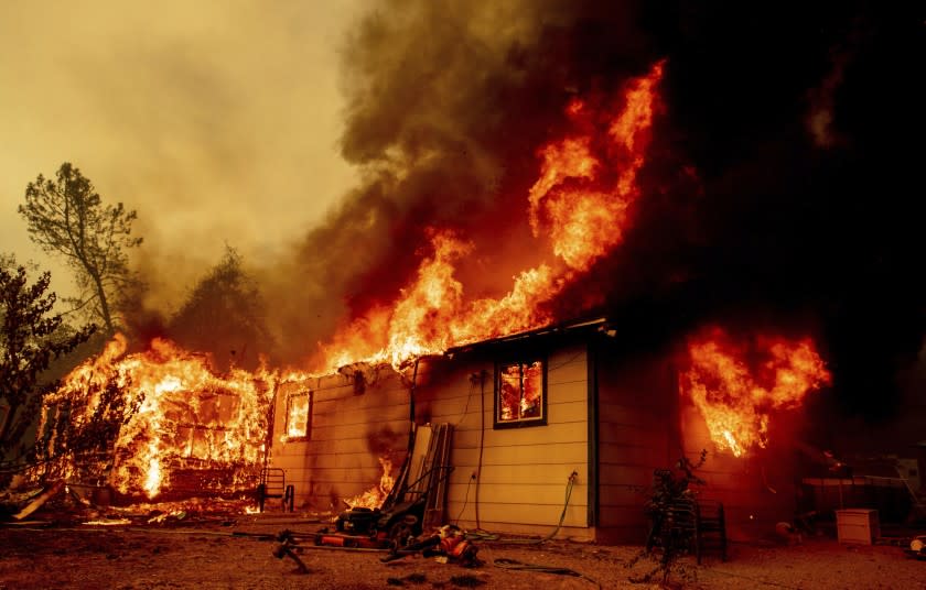 Flames consume a house near Old Oregon Trail as the Fawn Fire burns about 10 miles north of Redding in Shasta County, Calif., on Thursday, Sep. 23, 2021. (AP Photo/Ethan Swope)