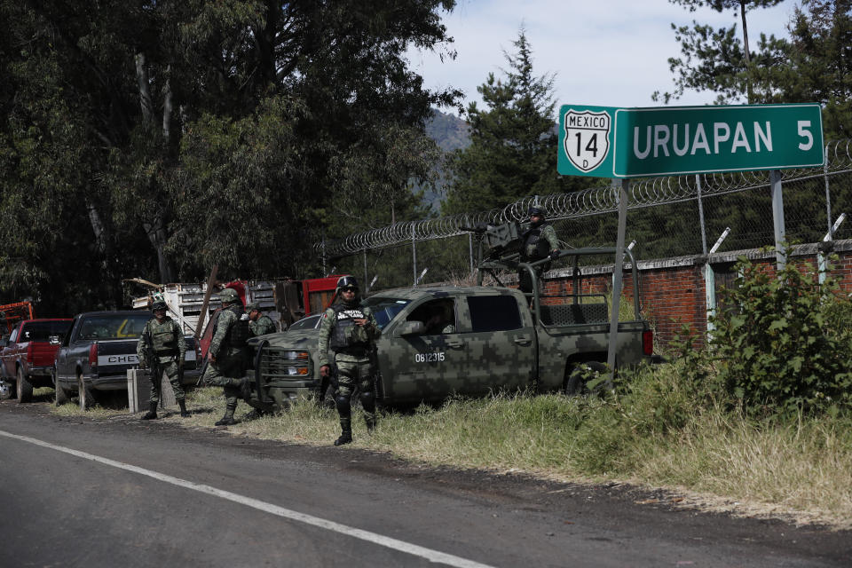 In this Feb. 6, 2020.photo, National Guards patrol along the road leading into Uruapan, Michoacan state, Mexico. Uruapan, a city of about 340,000 people, is in Mexico's avocado belt, where violence has reached shocking proportions. In Uruapan, cartels are battling for territory and reports of killings are common, such as the gun massacre last week of three young boys, a teenager and five others at an arcade in what had been a relatively quiet neighborhood. (AP Photo/Marco Ugarte)