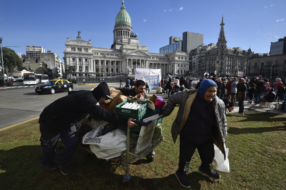 Street food vendors arrive to set up their stall outside Congress where protesters are expected to gather as lawmakers debate reforms backed by President Javier Milei in Buenos Aires, Argentina, Thursday, June 27, 2024. (AP Photo/Gustavo Garello)