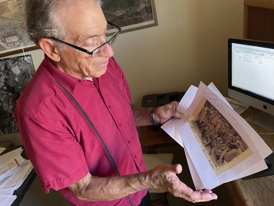 In this July 8, 2021, photo, adjunct history professor and research associate Larry Larrichio holds a copy of a late 19th century photograph of some of the first pupils at an Indigenous boarding school in Santa Fe during an interview in Albuquerque, New Mexico. Larrichio's discovery hints at the immensity of the challenge ahead of the U.S. Interior Department as it investigates the boarding school legacy. (AP Photo/Susan Montoya Bryan)