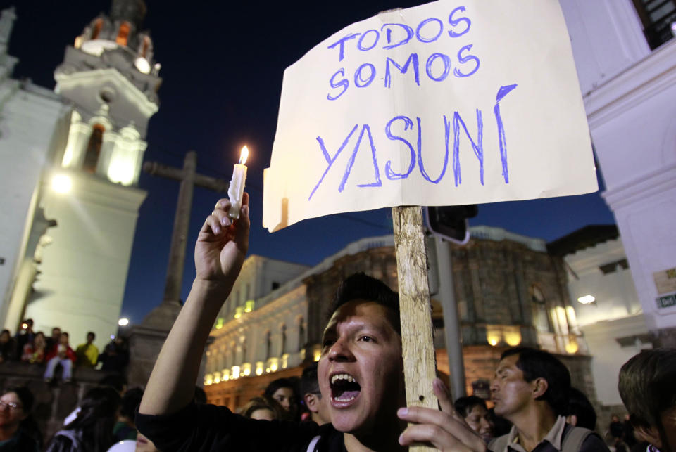 FILE - In this Aug. 22, 2013, file photo, a young man holding a sign that reads in Spanish; "We are all Yasuni," joins others in a candlelight vigil in front of the government palace in protest against President Rafael Correa's decision to allow oil drilling in the Amazon reserve, Yasuni National Park, in Quito, Ecuador. Ecuador's electoral council on Tuesday May, 6. 2014, rejected as insufficient a petition drive calling for voters to decide whether to proceed with oil drilling in a pristine Amazon nature reserve as planned by President Rafael Correa. (AP Photo/Dolores Ochoa, File)