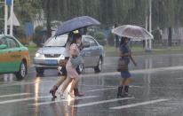 Women walk with umbrellas during torrential rains, Wednesday, August 5, 2020, in Pyongyang. North Korea says torrential rains have lashed the country, prompting outside worries about possible big damages in the impoverished country. (AP Photo/Cha Song Ho)