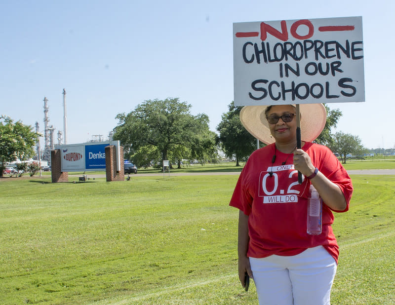 A member of Concerned Citizens of St. John Parish holds a sign that reads "No chloroprene in our schools" outside the facility DuPont sold to Denka in 2015.