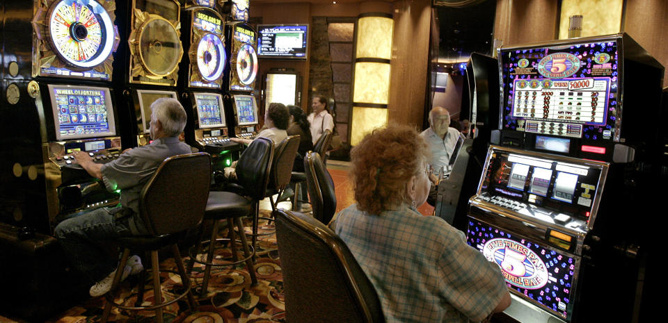 FILE - Patrons at the San Manuel Indian Bingo & Casino play slot machines June 8, 2006, on the San Manuel Indian Reservation, Calif. The campaign that could bring legalized sports betting to California has become the most expensive ballot-initiative fight in state history, pitting wealthy Indian tribes against online gambling companies in a contest over what could become the nation's most lucrative marketplace. A committee to defeat Proposition 27 is backed by tribes, including the San Manuel Band of Mission Indians, and has pulled in about $91 million. (AP Photo/Ric Francis, File)