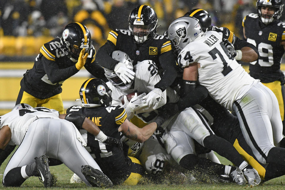 Las Vegas Raiders running back Josh Jacobs (28) is tackled during the second half of an NFL football game against the Pittsburgh Steelers in Pittsburgh, Saturday, Dec. 24, 2022. (AP Photo/Don Wright)