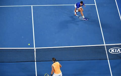 Serbia's Novak Djokovic (top) hits a return against Spain's Rafael Nadal during the men's singles final on day 14 of the Australian Open tennis tournament in Melbourne on January 27, 2019 - Credit: AFP