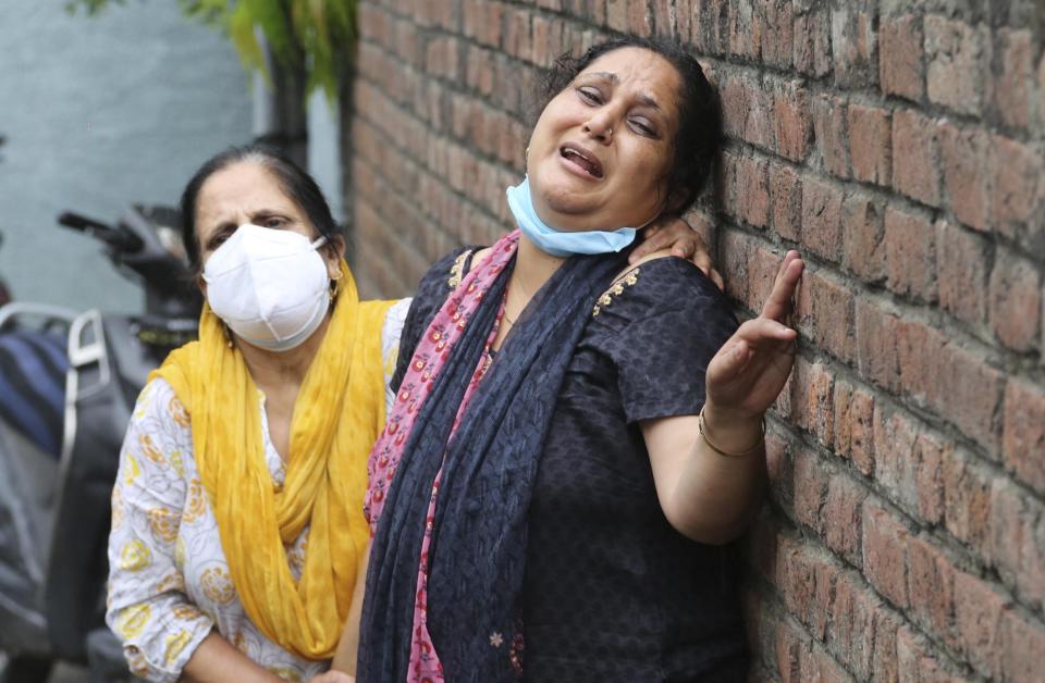 Relatives of Rakesh Pandita, a politician who was killed late Wednesday, mourns at their residence in Jammu, India, Thursday, June.3, 2021. Assailants fatally shot the politician belonging to India’s ruling party in disputed Kashmir, police said Thursday, blaming separatist rebels for the attack. The unidentified assailants fired at Pandita late Wednesday in the southern town of Tral, where he was visiting a friend, police said. He was declared dead in a hospital. (AP Photo/Channi Anand)