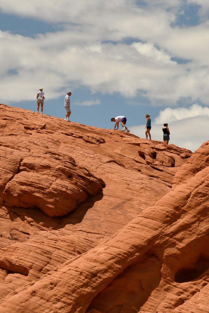 People hike on red rocks at Valley of Fire State Park 