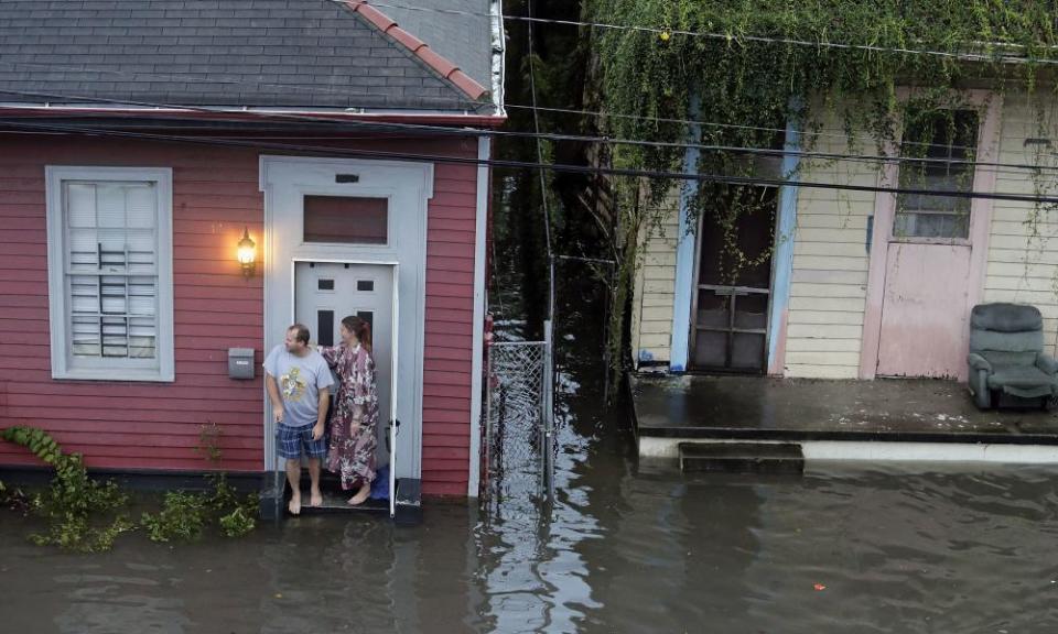 People stand outside their home in floodwaters in New Orleans on 5 August.