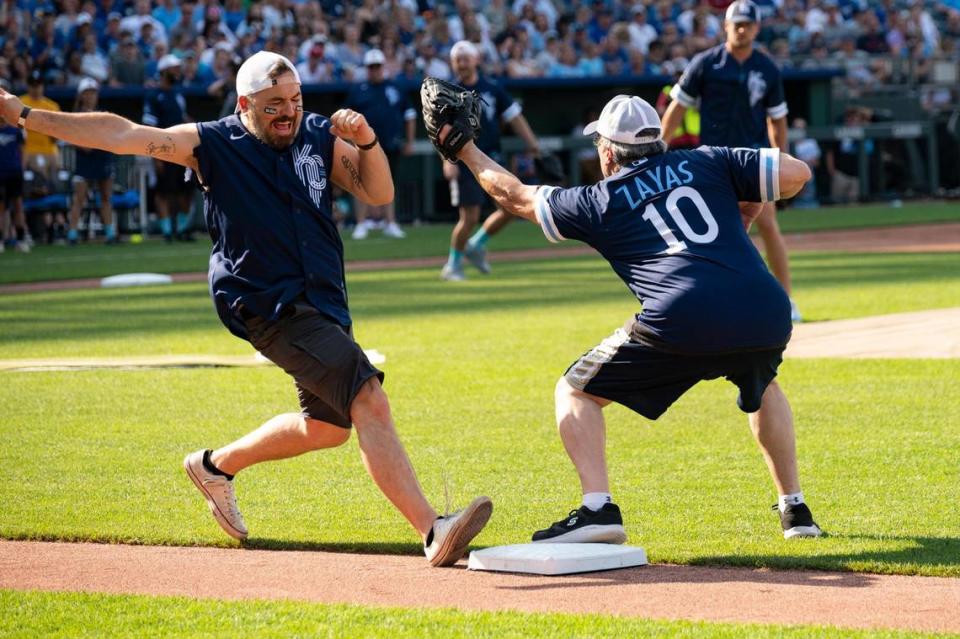 Brian Quinn of “Impractical Jokers” lunges for first base as David Zayas (“Dexter”) tries to tag him out during the Big Slick celebrity softball game at Kauffman Stadium Friday.