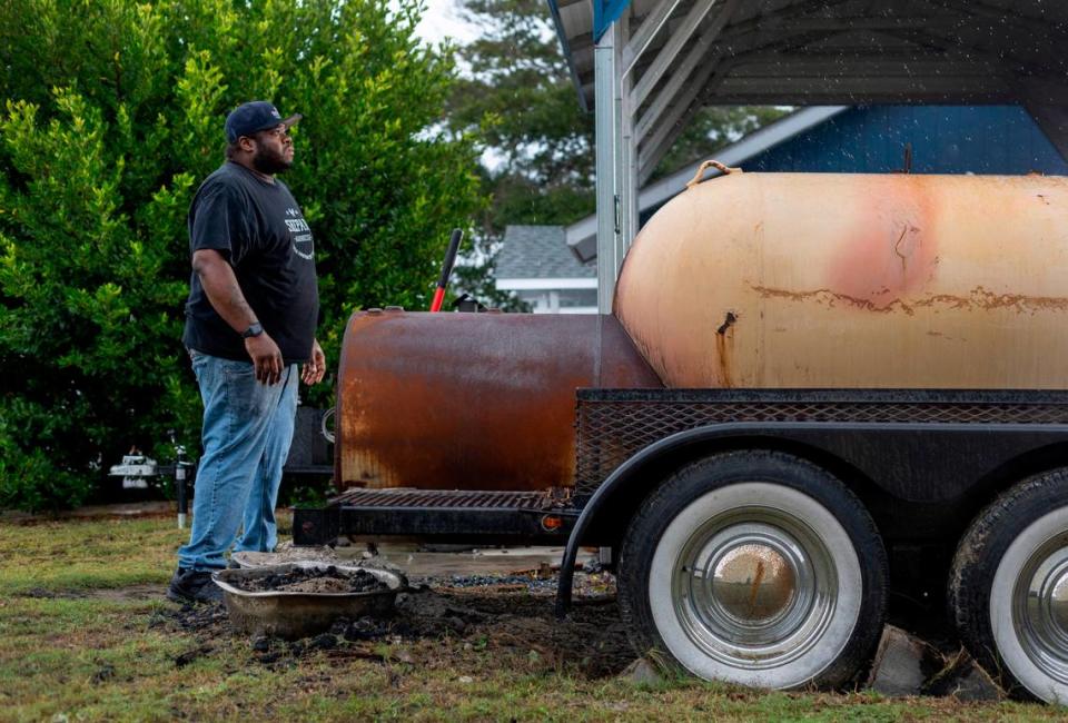 Rain from Tropical Storm Ophelia starts to fall as Brandon Shepard tends to the fire in his cooker at his restaurant, Shepard Barbecue on Friday September 22, 2023 in Emerald Isle, N.C.